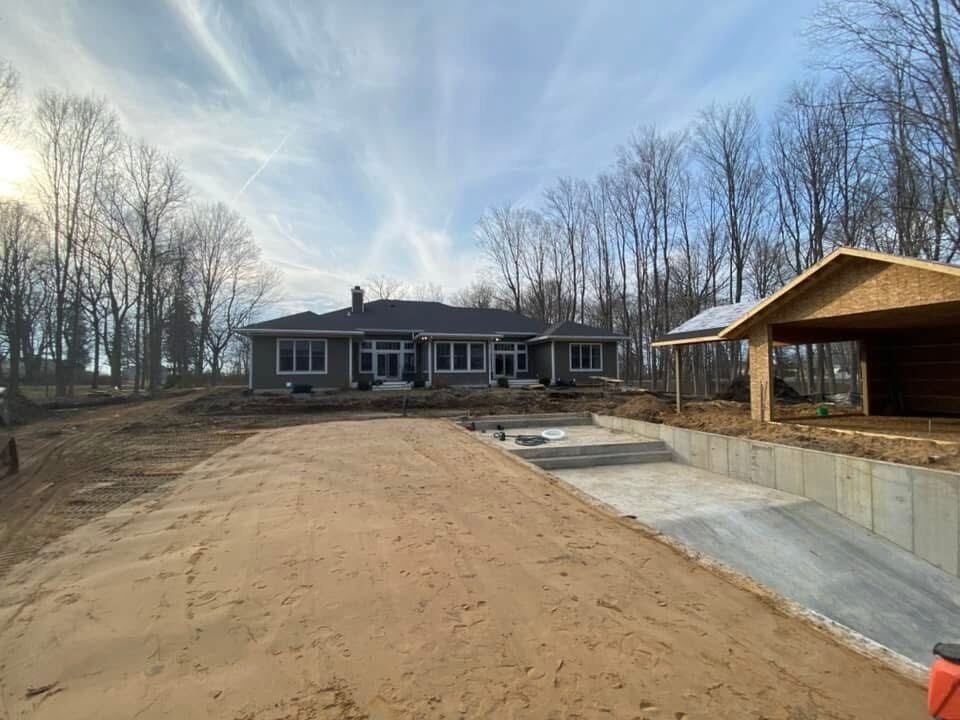 Finished home with a freshly graded driveway and yard