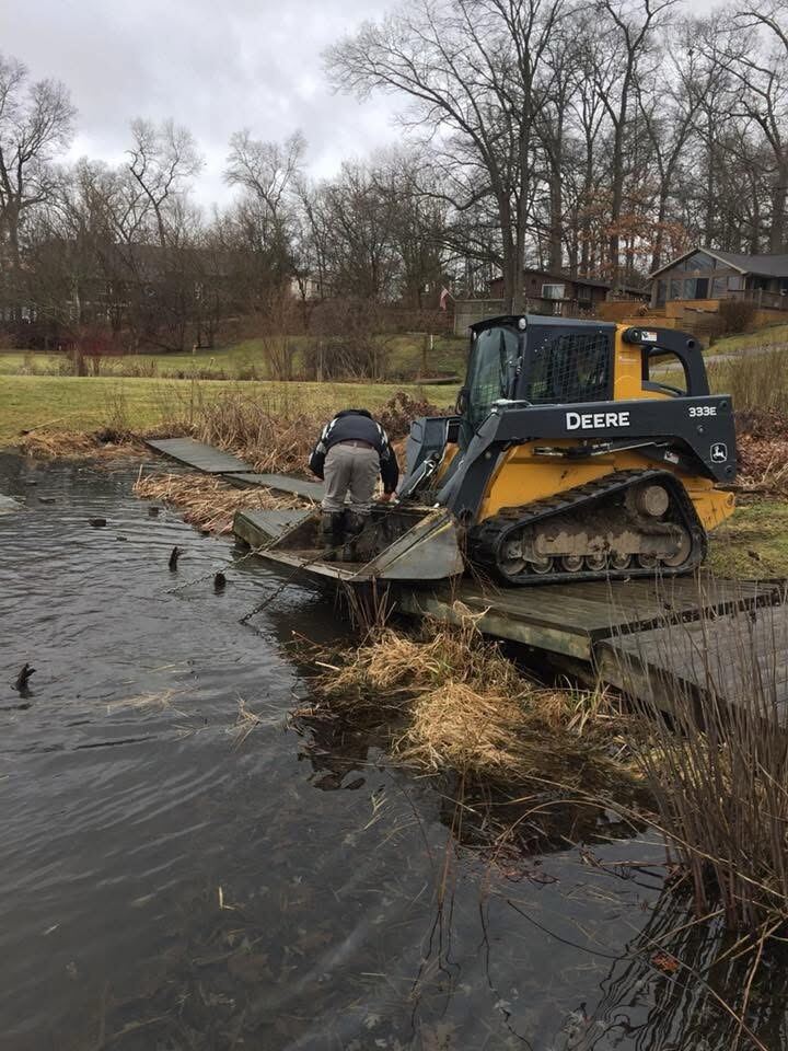 Winter pond edge work along a dock
